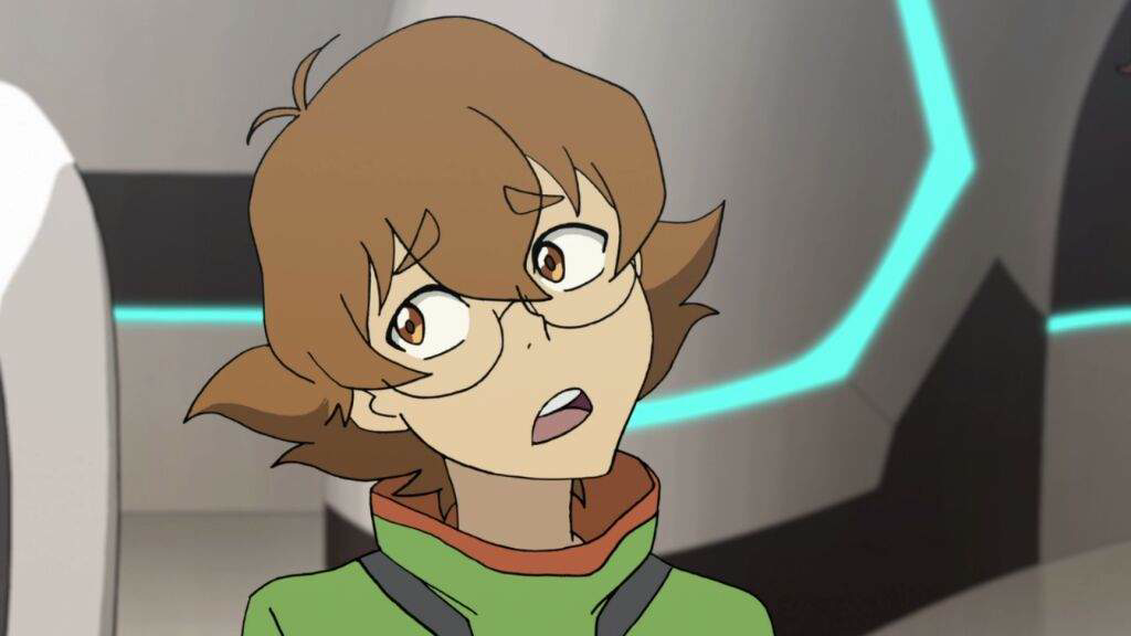 A screenshot from Voltron Legendary Defender. It shows a girl with round glasses and slightly poofy brown hair to her neck. She's looking sideways, seemingly in conversation. She's wearing a green hoodie with a orange strip on the neck and black accents.